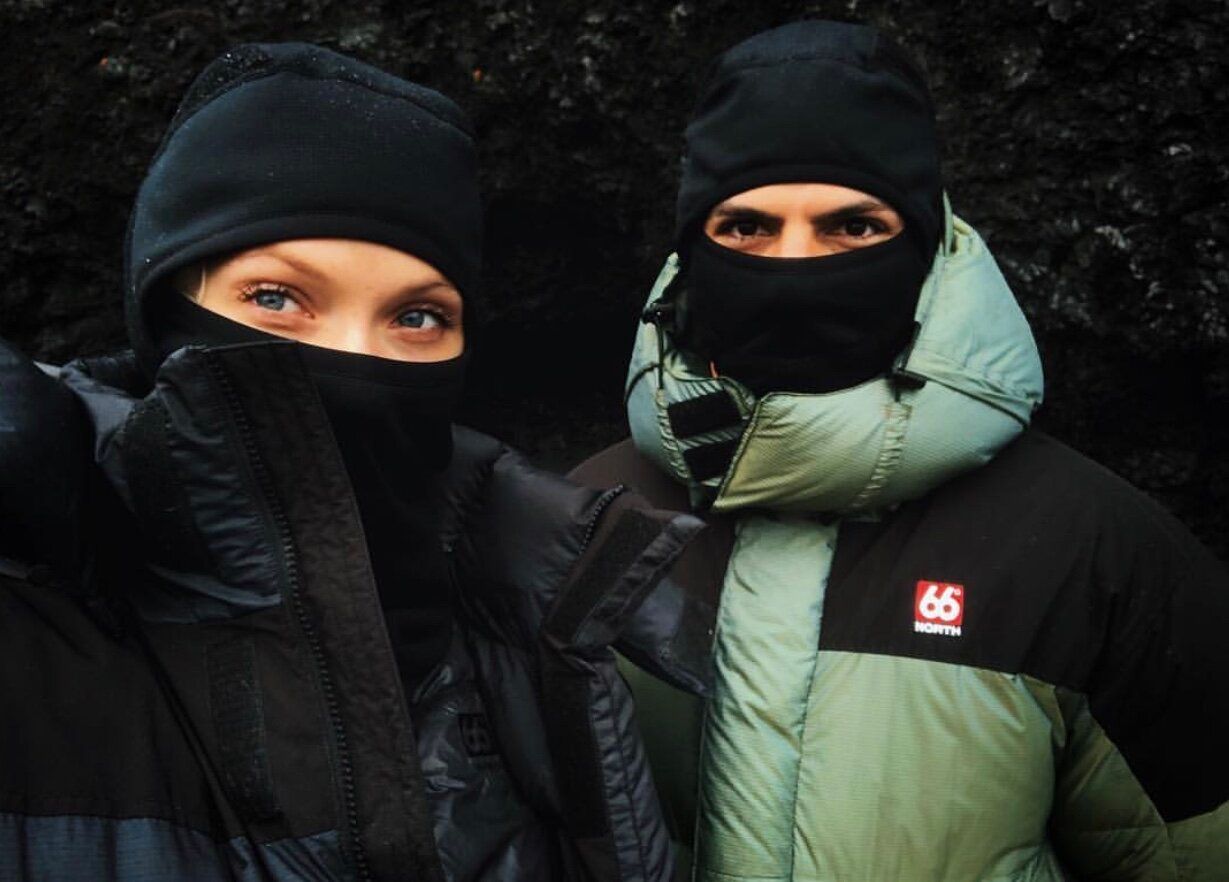Mads Emil Møller and another person wearing winter clothing in a dark, rugged outdoor setting.