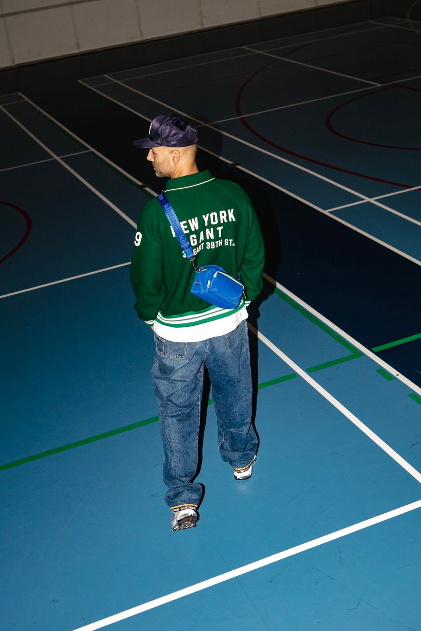 Mads Emil Møller walks on a basketball court wearing casual streetwear and a cap.