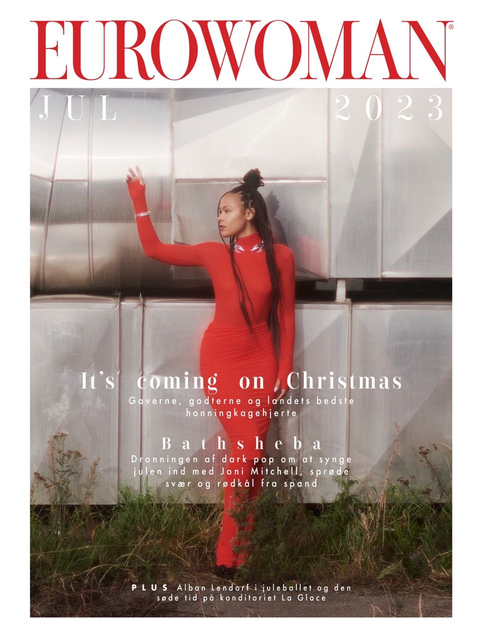 Bathsheba poses in a red outfit against metallic background, exuding confidence and style.