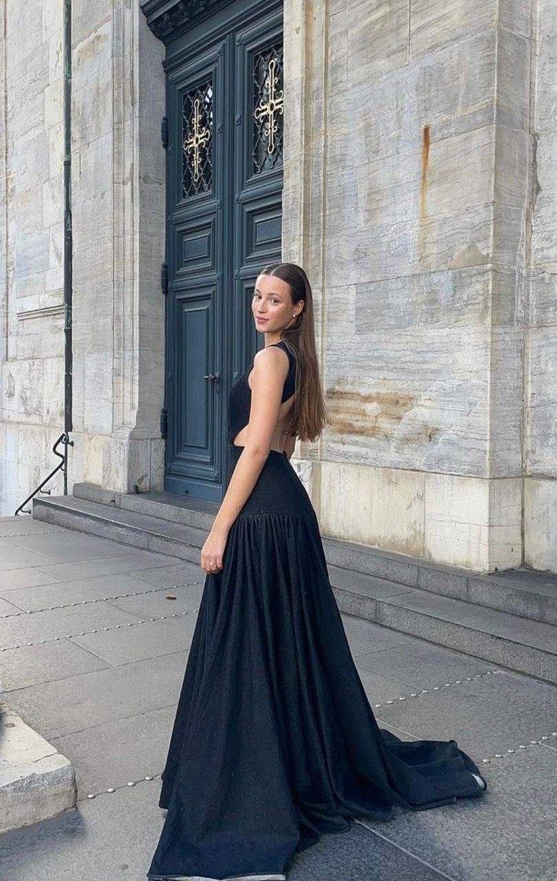 Josephine Højbjerg poses in a black gown outside a historic building.